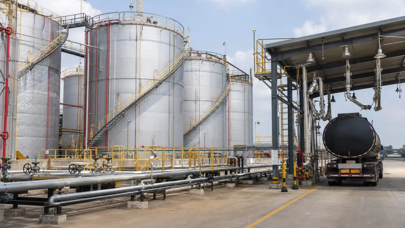Industrial bitumen storage tanks and transfer piping at a bulk terminal